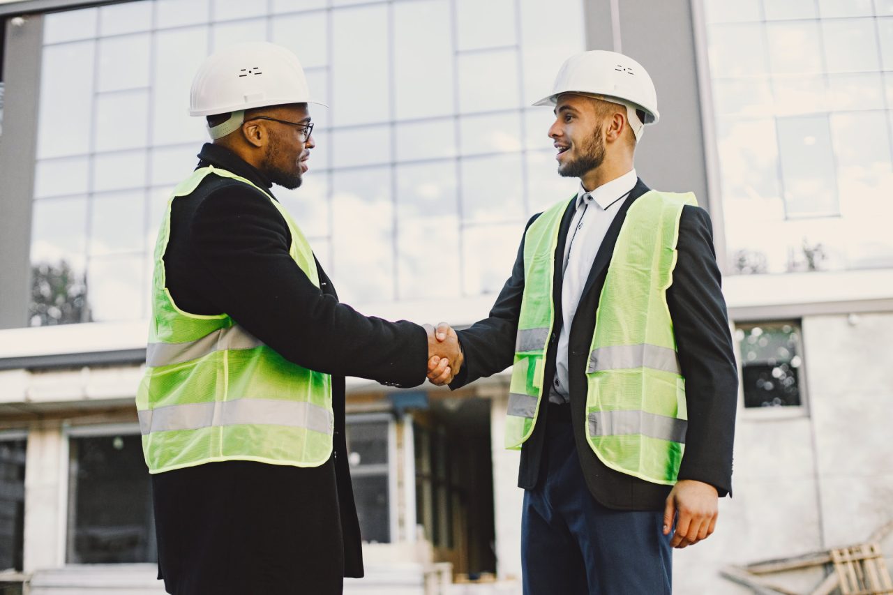 Builders handshaking on building site